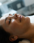 A person lying down, likely receiving a cosmetic treatment such as LED light therapy or a facial peel.
