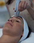 A person receiving a skin tightening treatment with a device on their face.