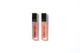Two tubes of GERI G. lip butter gloss in pink and nude shades, set against a white background.