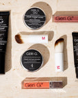 Collection of GERI G makeup products on a textured beige background