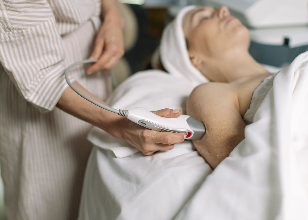 Person receiving a facial treatment with a device in a spa setting