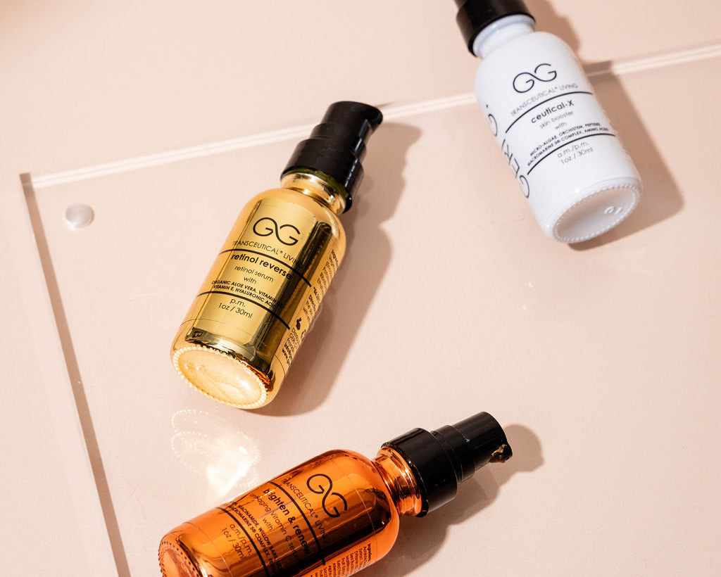 Three bottles of GG skincare products on a beige surface