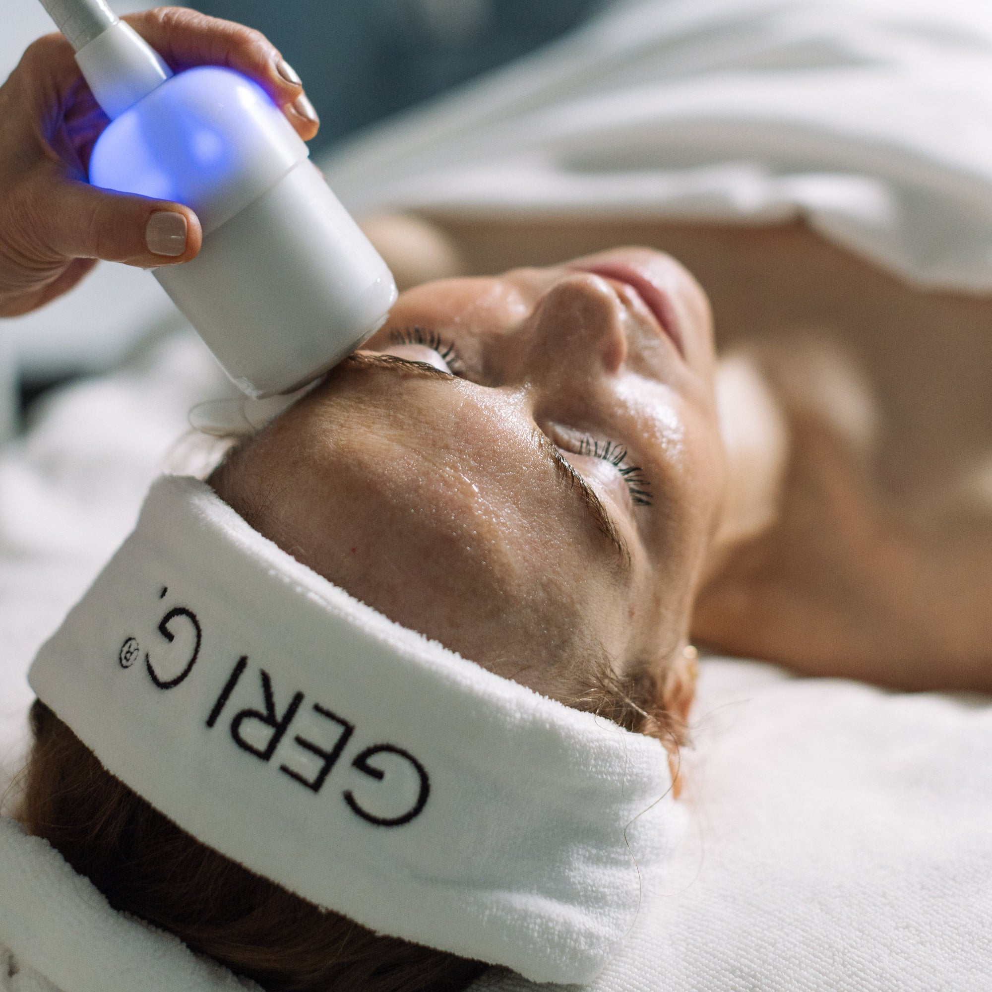 Person receiving a facial treatment with a device labeled 'GERI G.'