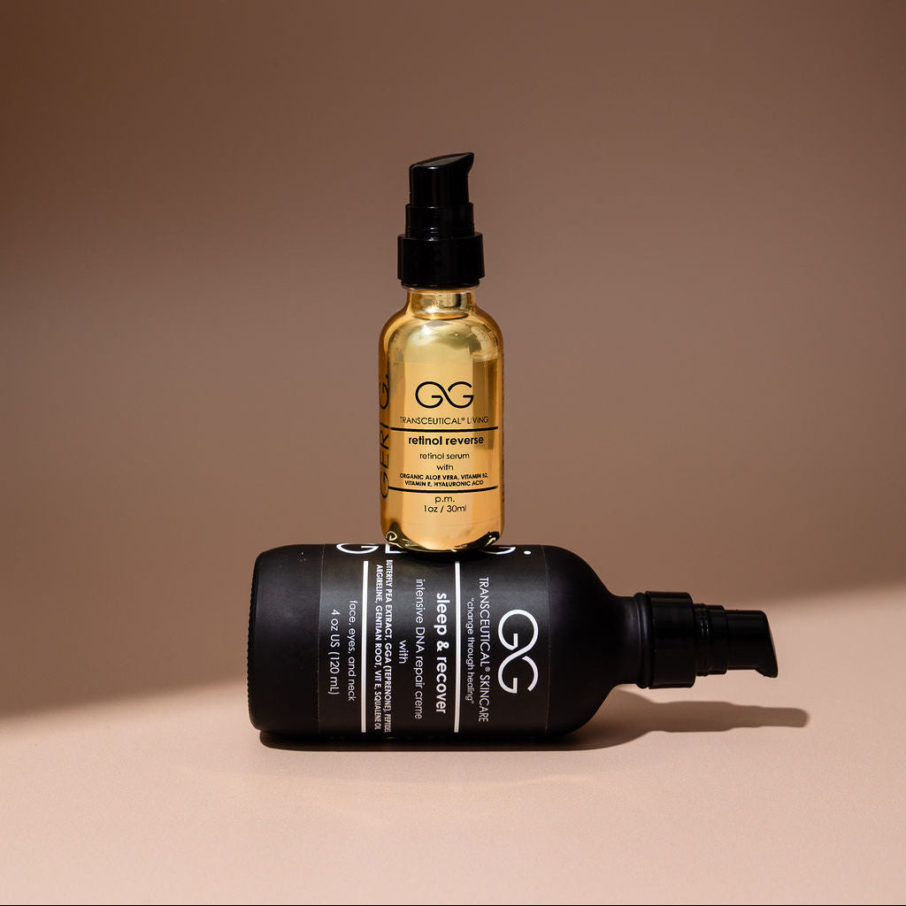 Two bottles of hair care products, one black and one gold, on a beige background.